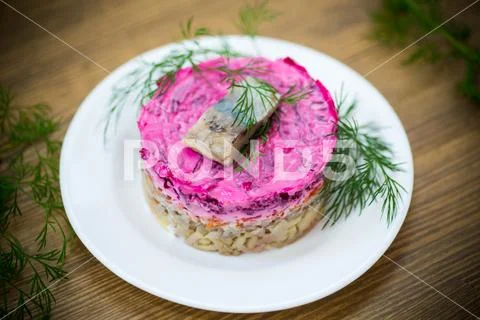 Layered salad of boiled vegetables with beets and herring Stock Photos