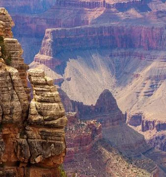 Layered sandstone cliffs and rugged rock formations overlooking expansive c.. Stock-Fotos