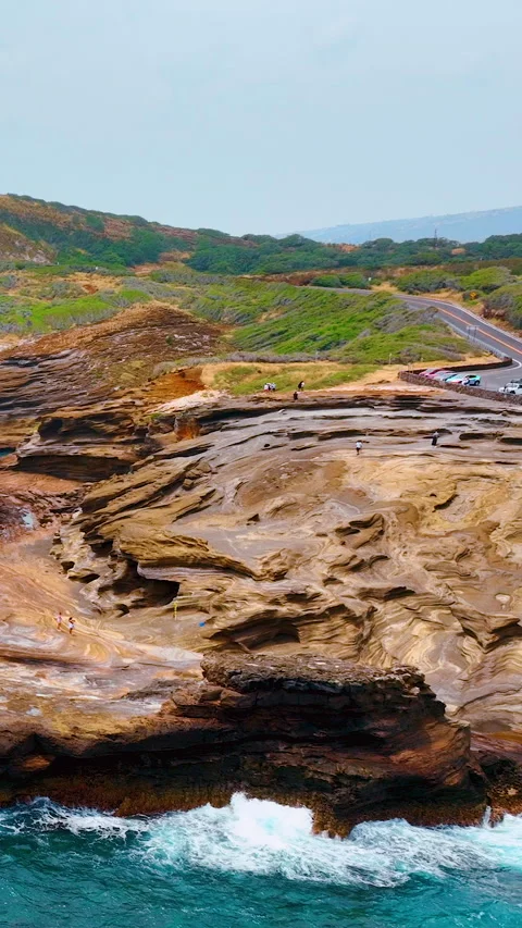 Layered Sandstone Rock Platform With Road and Ocean Waves Vertical video. 스톡 동영상 335388924