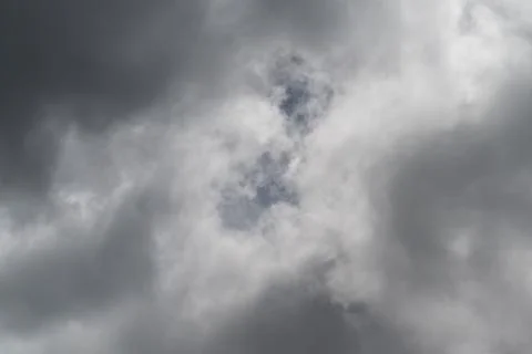 Layered thunder clouds promise rain. Dramatic motion captured in monochrome t Stock Photos