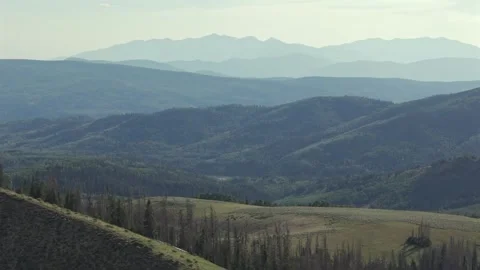 Layered Uinta Mountain Ranges and Rolling Hills Under Hazy Sky Stock Footage 339494373