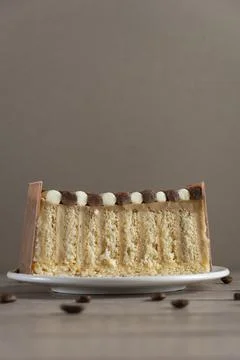Layered Vanilla Cake Slice on Plate with Coffee Beans Stock-Fotos