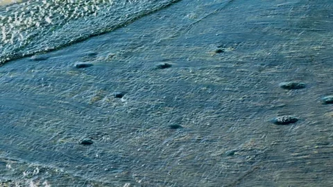 Layered waves moving across a shallow sandy coastal shoreline Stock Footage 346612084