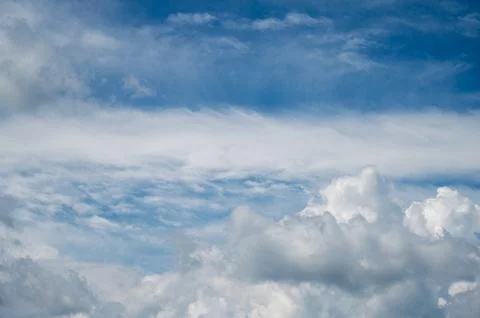 Layered white clouds across deep blue dramatic summer sky 스톡 사진