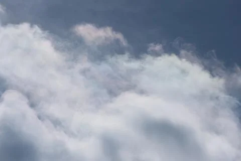 Layered white clouds drifting across a deep blue sky Stock Photos