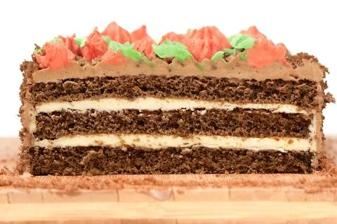 Layers of biscuit cake decorated with multi-colored buttercream flowers. Stock Photos