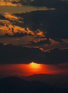 Layers of dramatic sky at sunset over the mountains Stock Photos
