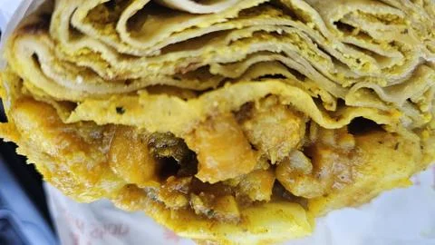 Layers of flaky flatbread filled with savory curry. Stock Photos