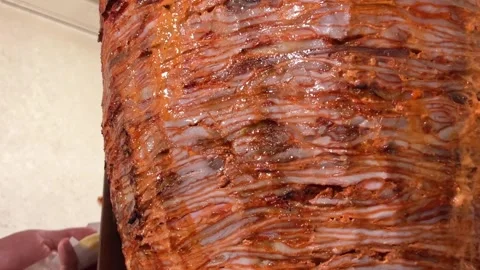 Layers of marinated meat stacked tightly on a skewer being prepared for cooking Stock Footage 295030195