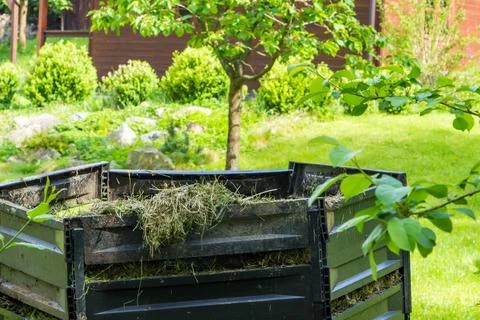 Layers of rotting compost in plastic composter bin in spring garden in village Stock Photos