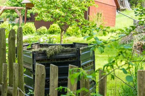 Layers of rotting compost in plastic composter bin in spring garden in village Stock Photos