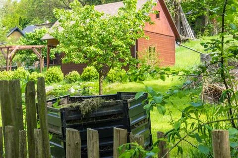 Layers of rotting compost in plastic composter bin in spring garden in village Stock Photos