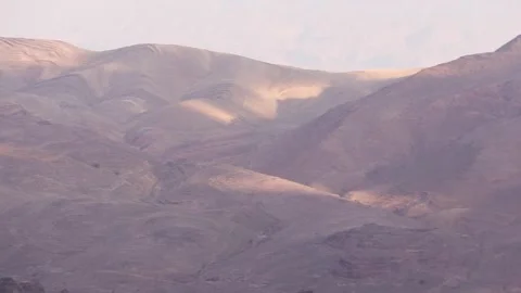 Layers of rugged desert mountains illuminated by morning sunrise in Jordan Vidéo 338158125