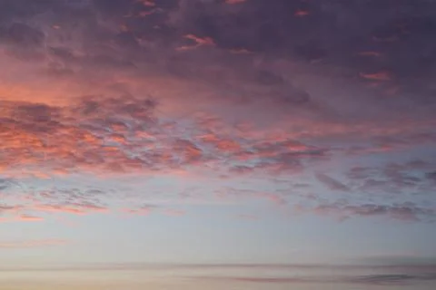 Layers of sunset. Fluffy clouds. Romantic sky. Universal vertical photo. Stock Photos