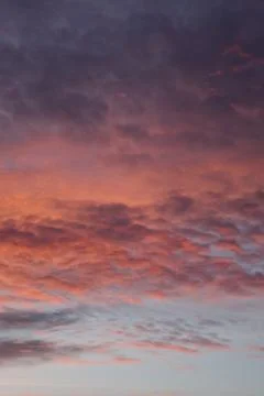Layers of sunset. Fluffy clouds. Romantic sky. Universal vertical photo. Stock Photos