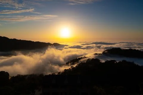 Layers of surging clouds are very spectacular. Sunset behind the mountains. Stock Photos