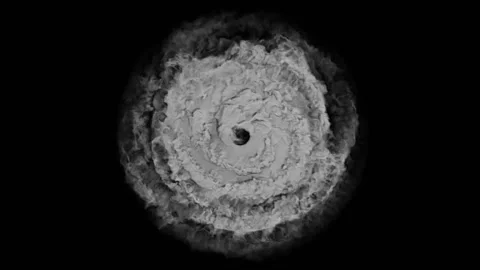 Layers of thick gray smoke spiral counterclockwise against a black background Stock Footage 169201090