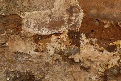Layers of various colours of plaster crack away from a brink wall, great for  Stock Photos
