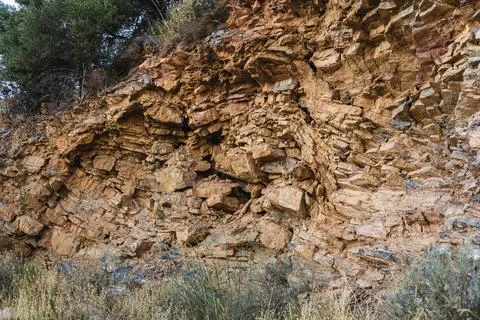Layers of various limestone rocks visible in the exposed mountainside Stock Photos