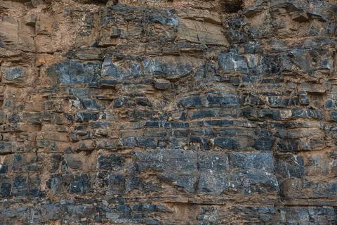 Layers of various limestone rocks visible in the exposed mountainside Photos
