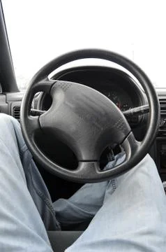 Laying back on the inside of a car with a black leather steering wheel Stock Photos