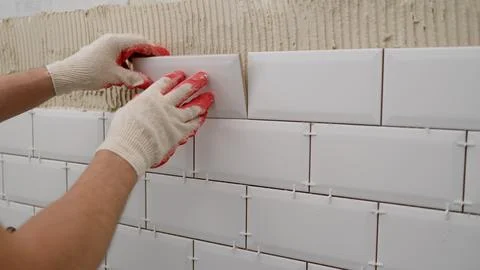 Laying backsplash tiles in the kitchen. Tile apron in the kitchen. White tile Stock Photos