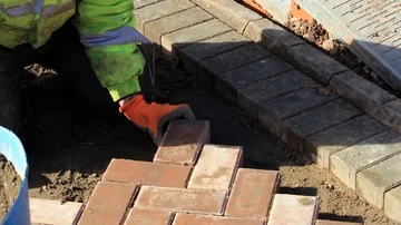 Laying brick paving in driveway Stock Footage 85925754