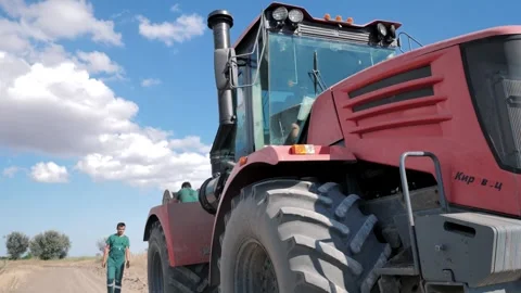 Laying the cable in the ground with a large wheeled tractor Stock Footage 247988654