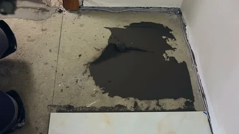 Laying a ceramic or porcelain tile floor close-up. Worker laying slab. Repair Video stock 109184682