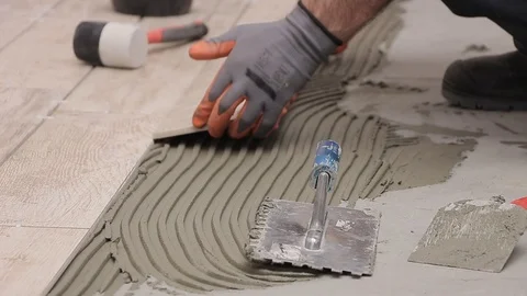 Laying ceramic tiles with cement adhesive on the floor Stock Footage 111865149