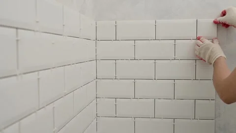 Laying ceramic tiles. Installing new tiles on a backsplash during a home Stock Footage 247219785