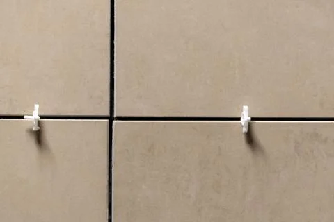 Laying ceramic tiles using plastic crosses. Use plastic crosses to align the  Stock Photos