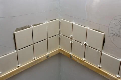 Laying ceramic tiles on the wall using crosses. Stock Photos