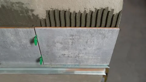 Laying ceramic tiles on the wall using tile leveling system Stock Photos