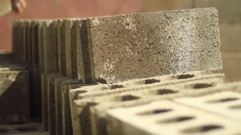 Laying construction blocks into a pile - 2 clips Stock Footage 37609405