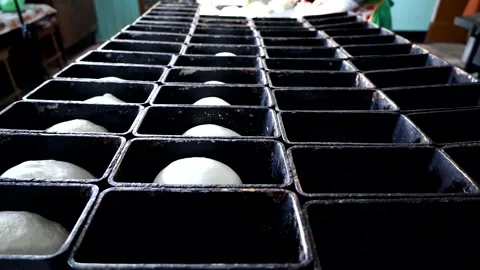 Laying the dough in the molds for future bread. Stock Footage 180457289