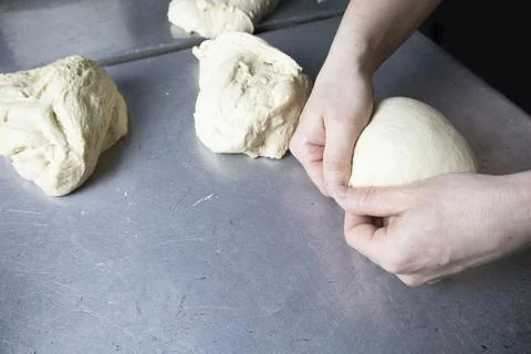 Laying the dough in the molds for future bread. Stock Photos
