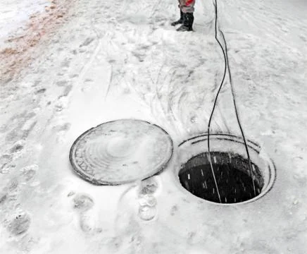 Laying of fiber optic cable through underground communications in  winter Stock Photos