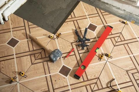 Laying floor ceramic tile. Tools for renovating floor Stock Photos