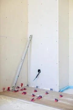 Laying flooring with tile leveling system during home renovation Stock Photos