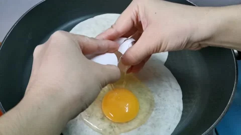 Laying Fresh Raw Egg on Top of Tortilla Wraps or Quesadilla Stock Footage 162876500