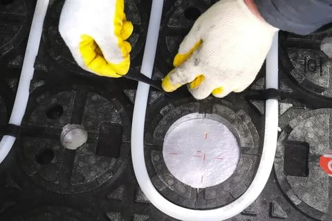 Laying of insulation elements and guides for underfloor heating system. Fotos de archivo