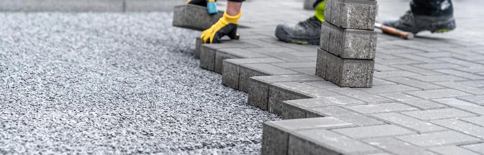 Laying interlocking pavers during the construction of sidewalks and roads Stock-Fotos