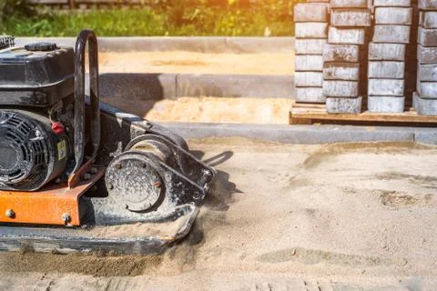 Laying paving slabs using a vibrator. Stock Photos