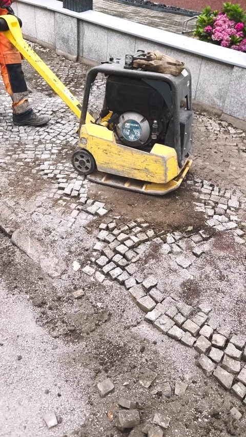 Laying paving stones using a vibratory plate Stock Footage 314217049