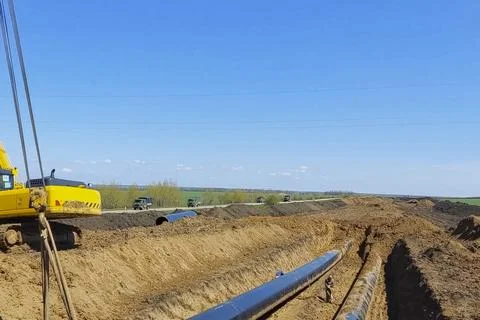 Laying pipelines in ditch with the help of pipelayer loaders, construction .. Фото