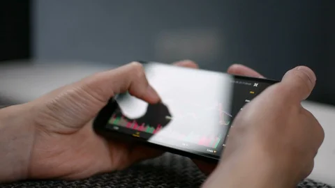 Laying on the sofa checking Bitcoin price chart on mobile phone screen, screen 動画素材 94169492