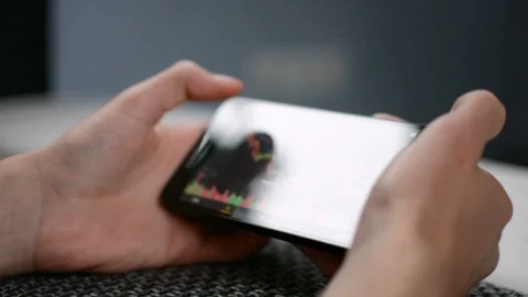 Laying on the sofa checking Bitcoin price chart on mobile phone screen, screen Stockbeeldmateriaal 94169790