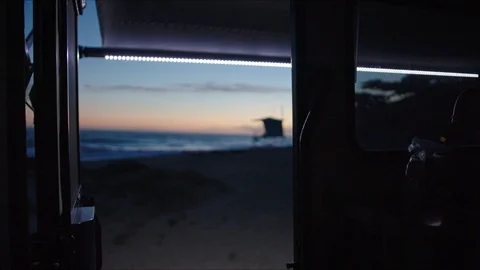 Laying in tent with view of sunset on ocean coast 動画素材 127409193