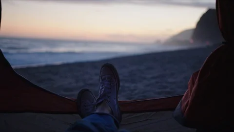 Laying in tent with view of sunset on ocean coast 库存影片 127409275